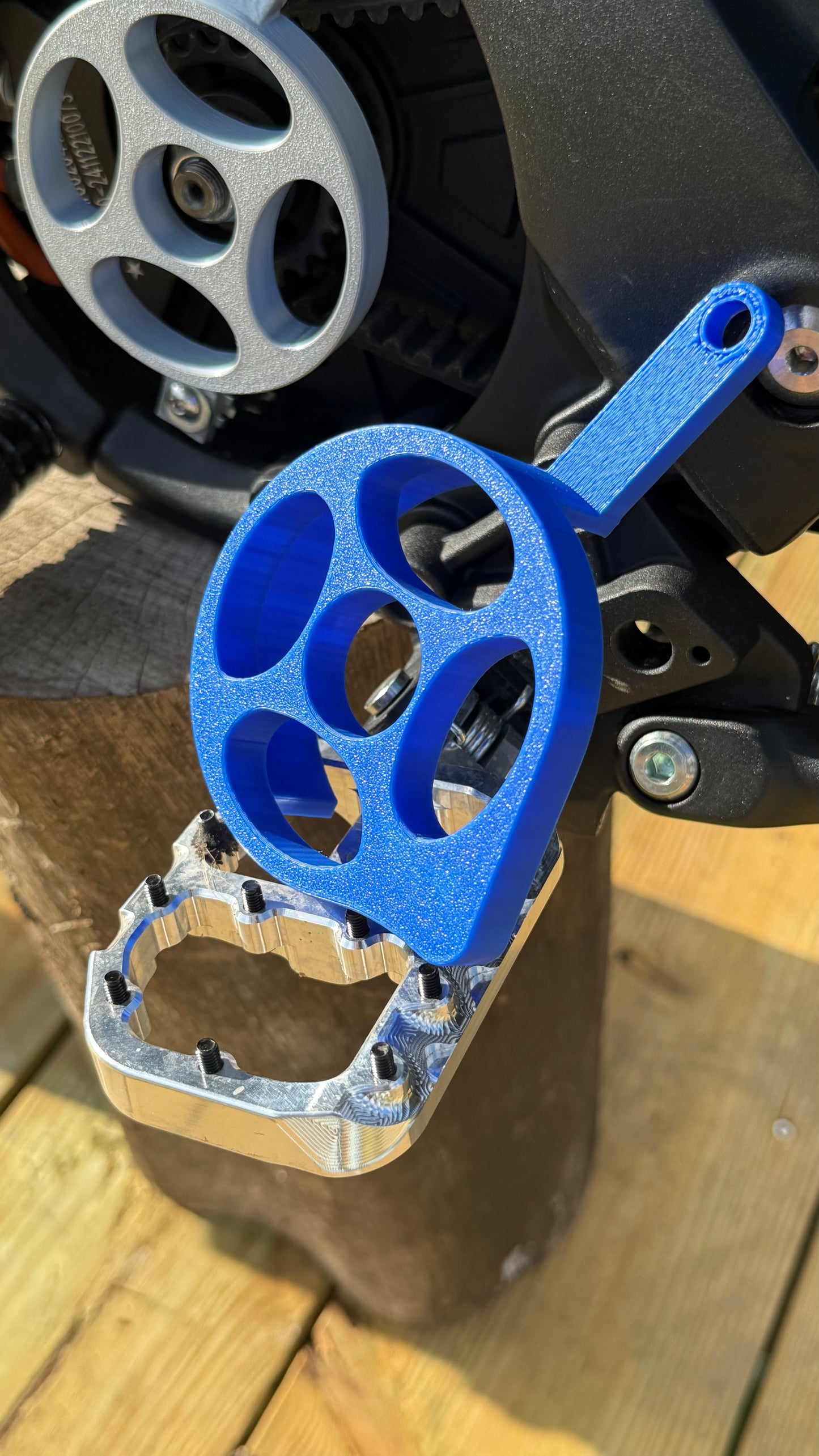 A blue motor cover for a Talaria x3 electric bike emoto, mounted and installed on the bike's motor area, with visible bolts and mounting hardware.